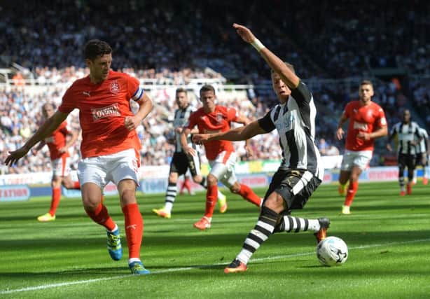 Newcastle United's Dwight Gayle, right, and Huddersfield Town's Mark Hudson in action during the SkyBet Championship match at St James's Park. Pic: PA.