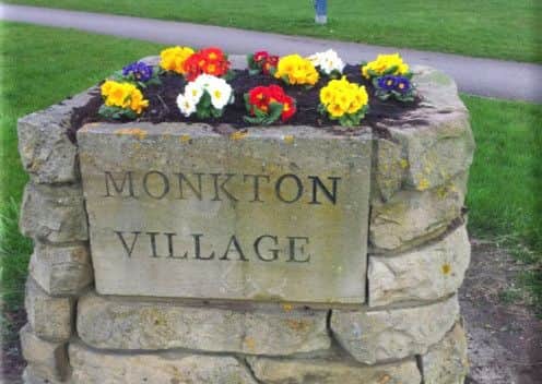 Flowers at the entrance sign to Monkton Village.