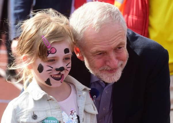 Labour leader Jeremy Corbyn with a young supporter at the Jarrow March at Monkton Stadium, Jarrow