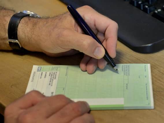 A GP writing out a prescription. Credit: PA.