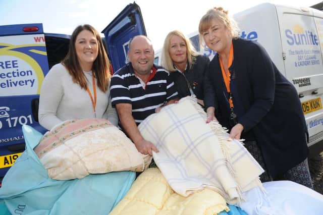 Hospitality and Hope volunteer Maureen Gribben, right, and Womens Aids Gemma Aslan, left, receive duvets and bedding from Stuart Urwin and Sunlites Joanne ONeil.