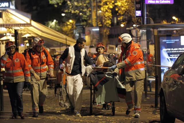 Medics evacuate an injured person on Boulevard des Filles du Calvaire, close to the Bataclan theatre after the shooting.