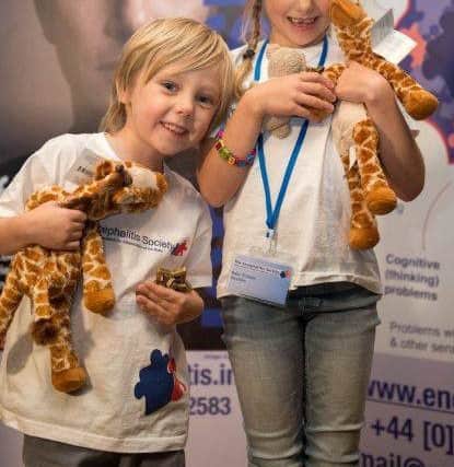 Jacob and Ruby Palmer aged four and six, collecting their awards at the Encephalitis Soceity Annual Meeting.