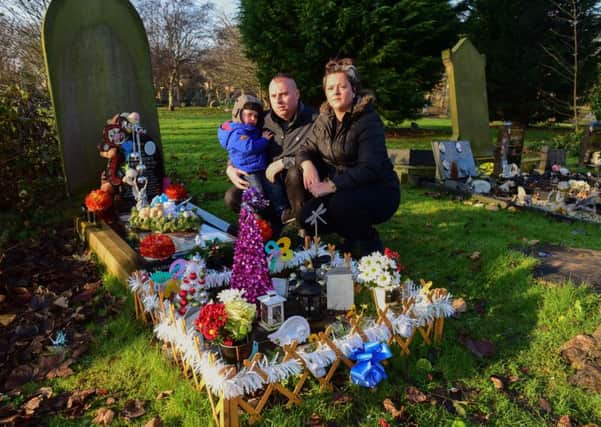 Julie Sweeting with Karl Herbertson and son Leon (2) at Kai's grave  in Harton Cemetery.