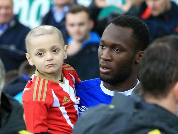 Bradley Lowery is carried onto the pitch by Romelu Lukaku before the Everton v Manchester City game. Pic: PA.