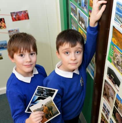 Fellgate Primary School pupils Travis Brown (left) and Tom woods pin postcards on to their classroom wall. Picture by FRANK REID