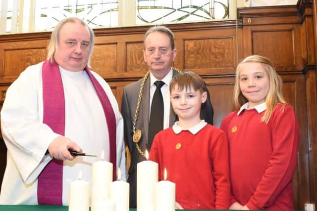 Father Adrian Dixon with the Mayor of South Tyneside, councillor Alan Smith, marking Holocaust Memorial Day at Hedworthfield Primary School students Kane and Kaci.