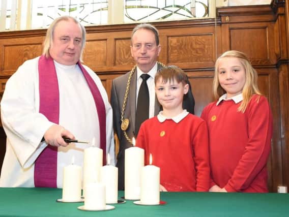 Father Adrian Dixon with the Mayor of South Tyneside, councillor Alan Smith, marking Holocaust Memorial Day at Hedworthfield Primary School students Kane and Kaci.