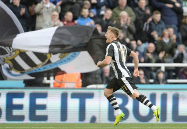 Flags fly in the background as Matt Ritchie celebrates his winner against Derby