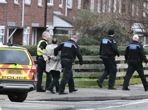 A man is led away by police after the incident in Moreland Road