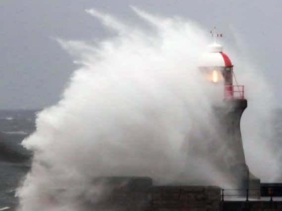 Waves crash over South Shields Lighthouse as high winds and rough seas hit the coast. Pic: PA.
