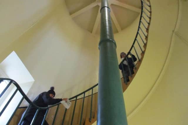 Souter conservation volunteers polishing the lighthouse staircase.