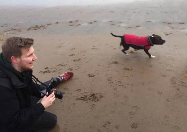 Michael Johnson with one of the model dogs on the beach.