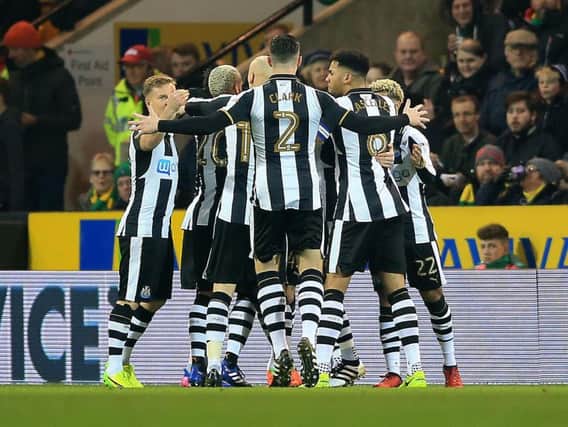 Newcastle players celebrate scoring at Carrow Road.
