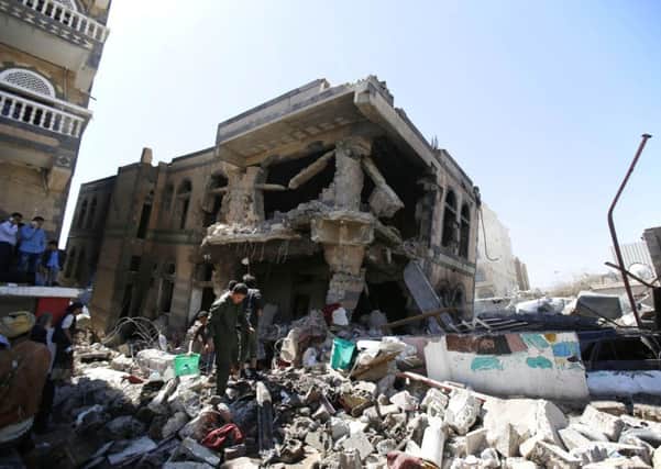 People inspect a house destroyed by Saudi-led airstrikes in Sanaa, Yemen.