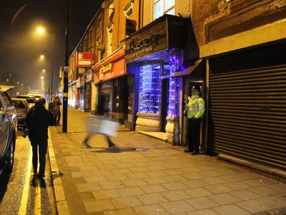 A officer stands guard outside the house raided by police in Birmingham. Photo by Press Association.