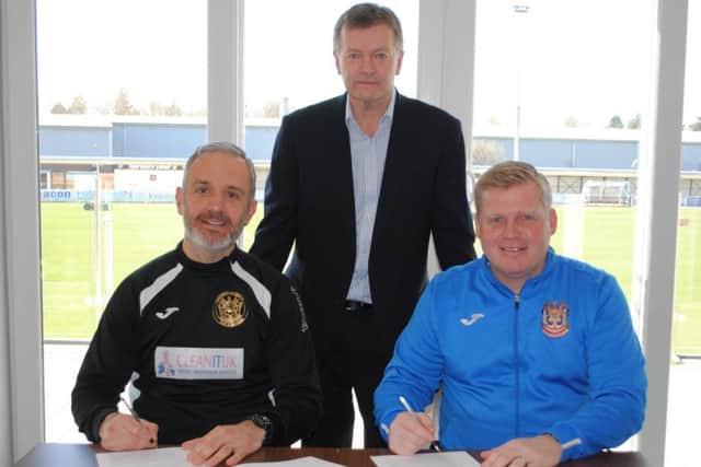 Lee Picton and Graham Fenton sign the new contracts, alongside managing director Michael Orr.