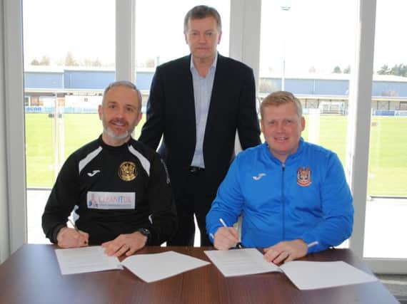 Lee Picton and Graham Fenton put pen to paper, with Managing Director Michael Orr watching on.