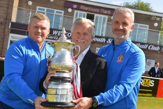 Geoff Thompson, centre, with South Shields joint managers Graham Fenton, left, and Lee Picton, right, and the Northern League trophy won by the club earlier this season.