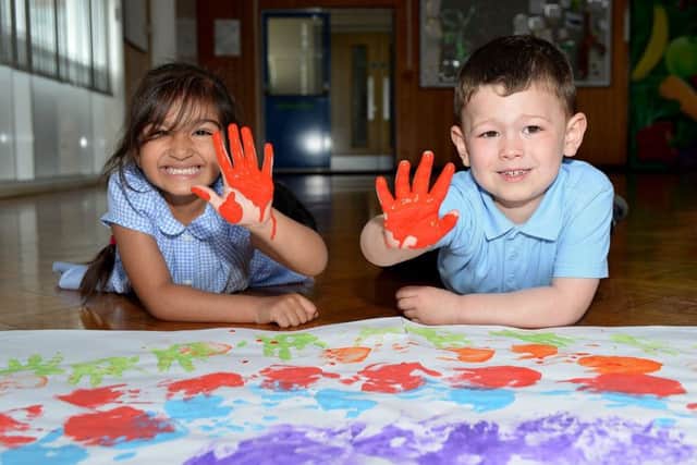 Laygate Community School pupils Deeti Joshi (3) and Noah Metcalfe before they add there painted hands to their art work.
