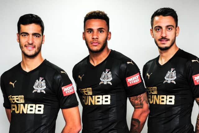 Mikel Merino, Jamaal Lascelles and Joselu modelling United's shirt the new sleeve sponsor MRF