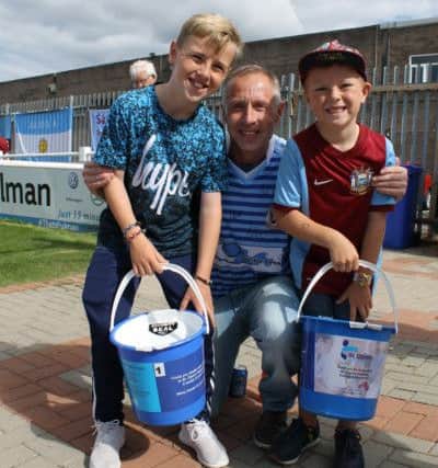 Roy Hammonds with grandsons Aaron and Zach at a fundraiser at Mariners Park last month. Image by Peter Talbot.
