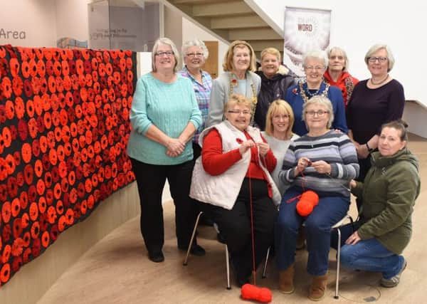 The Mayor, Councillor Olive Punchion and Mayoress, Mrs Mary French join the Knit and Natter group as they put the finishing touches to their poppy displays.