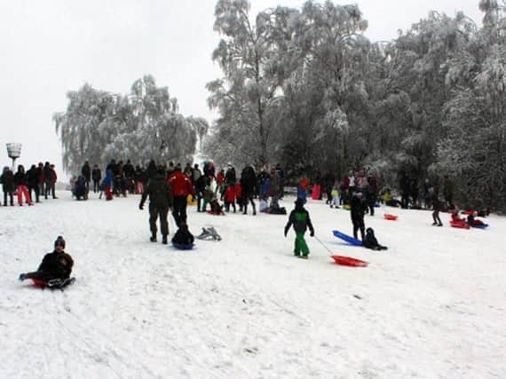 People take part in sledding on Gold Hill Common, Chalfont St Peter, in Buckinghamshire, today. Much of the country has been affected by snow and icy conditions.
