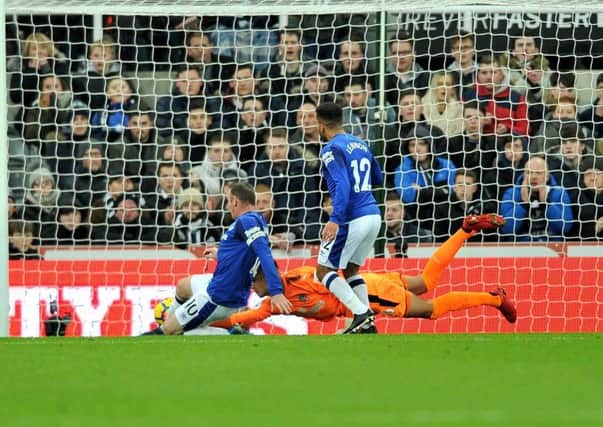 Wayne Rooney slides in to score for Everton after Karl Darlow spilled a header from Aaron Lennon.