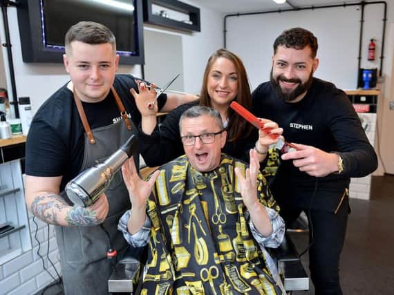 Shaun Rundle, left, and Stephen Richardson, right, from Urban Fades Barber Shop, with Jo Benham Brown from the Key Project, set about cutting the hair of Kevin Hall from the Key Project.