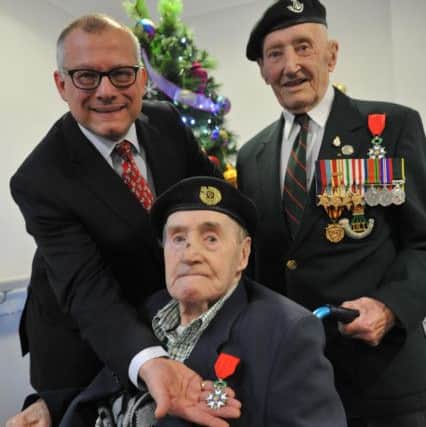 Jimmy McAdam receives his Legion d'Honneur medal from French Consul Eric Donjon, with fellow veteran Richard Atkinson.