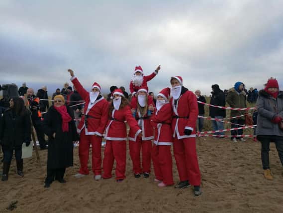 Six Santas get ready to take part in the Boxing Day dip today.
