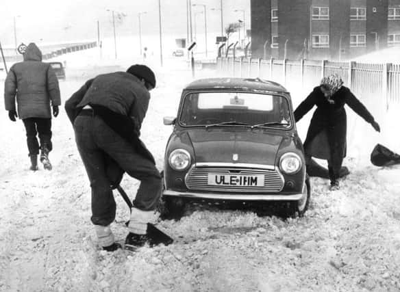 A man with a shovel tries to get this Mini moving in  February 1979..