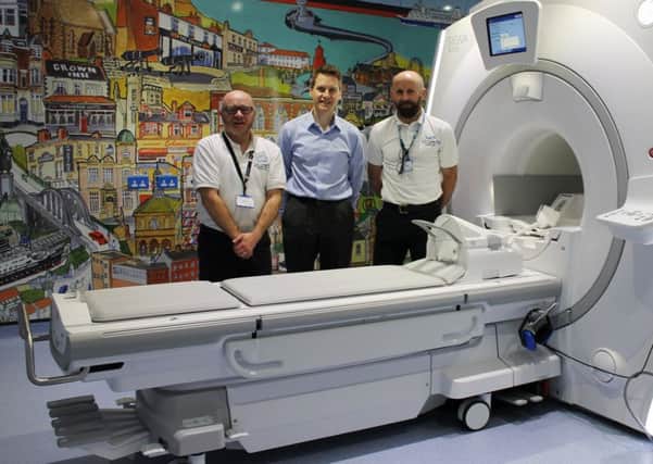 From left, radiographer David Barlow, lead consultant for radiology Dr Richard Cooper and MRI lead Miles Weston at the new MRI scanner, with a work by artist Bob Olley providing the backdrop