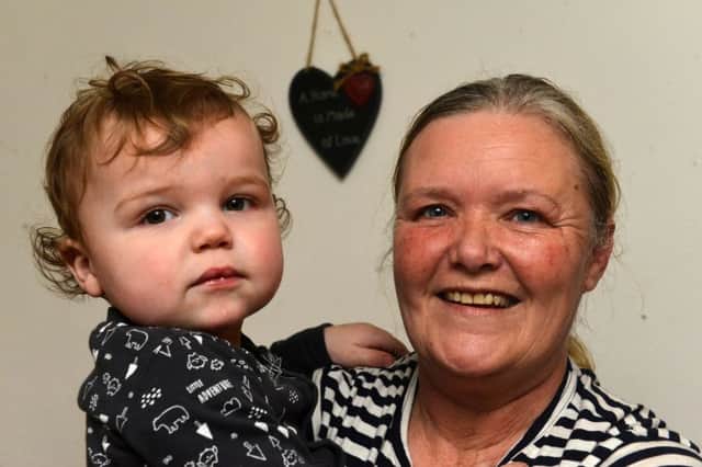 Toddler Miles McBurnie - who was saved by a fireman after a house blaze - with grandmother Ann Solomon.