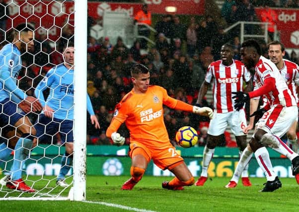 Karl Darlow makes a block from Stoke City's Mame Biram Diouf