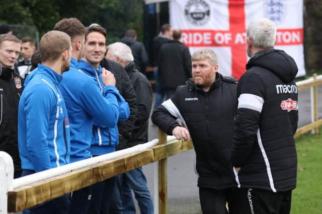 The South Shields players and management can only wait as the referee carries out his pitch inspection at Atherton Collieries. Pic: Peter Talbot.