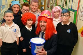 Headteacher Chris Rue and teacher Ann Walsh with pupils as the school marks World Cancer Day.