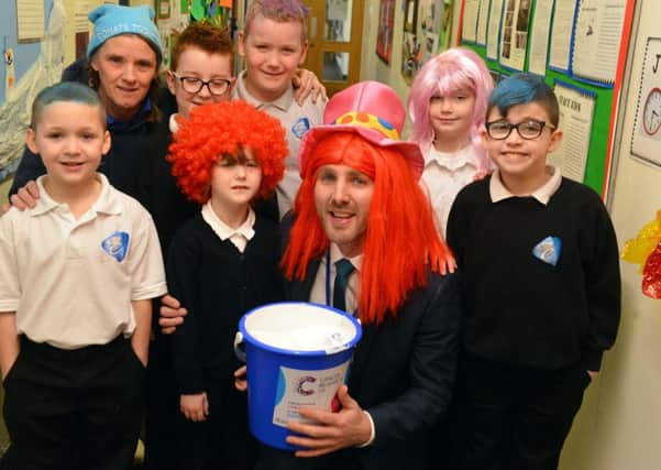 Headteacher Chris Rue and teacher Ann Walsh with pupils as the school marks World Cancer Day.