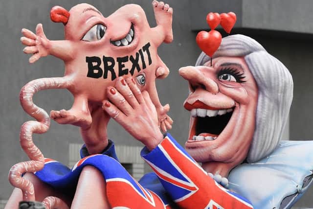 A float depicts Prime Minister Theresa May looking at her Brexit-baby during the traditional Rose Monday parade in Dusseldorf, Germany. Pic: AP Photo/Martin Meissner.