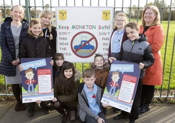 Pupils from Monkton Junior School  with Road Safety GB North East Look Out Leo mascot posters, along with Acting Headteacher Louise Heathfield, (left) and South Tyneside Council Road Safety Officer Julie Inkster, (right).