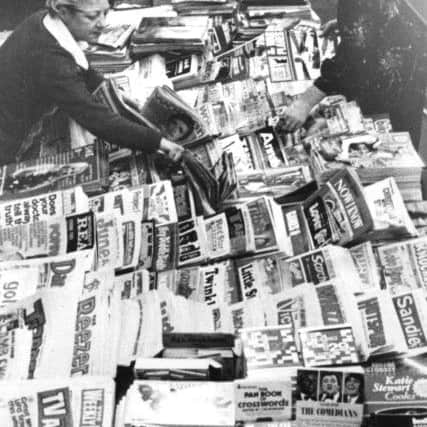 A newsagents shop, bursting with newspapers, comics and magazines.