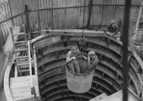 Men going down a tunnel in a bucket - but where were they?