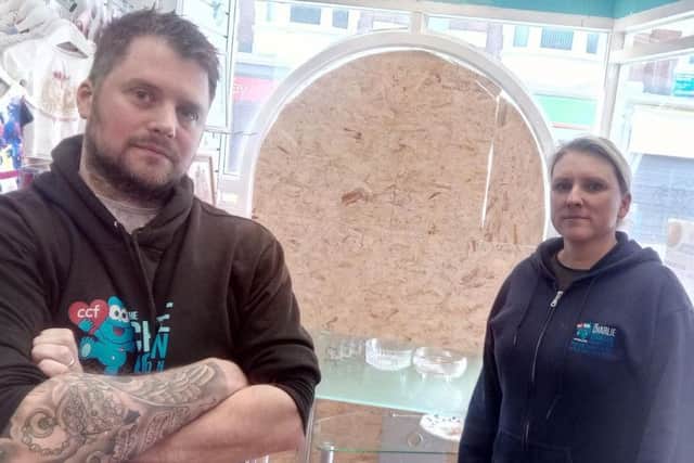 Chris Cookson and Joanne Nicholson beside the broken window at the charity shop.