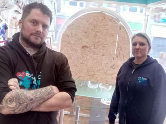 Chris Cookson and Joanne Nicholson beside the broken window at the charity shop.