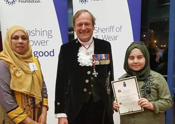 Representatives from Apna Ghar are presented with their award from the High Sheriff