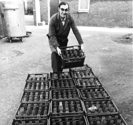 A school caretaker with crates of milk bottles. The subject of recycling  glass bottles is back in the headlines.