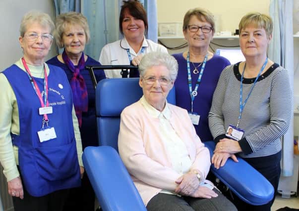 Margaret Whittington, of the League of Friends, sitting in one of the new chairs, with phlebotomy manager Kin Dailly, centre. and League members and supporters
