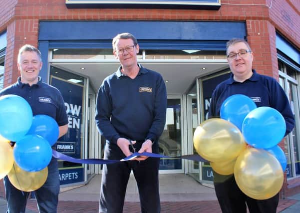Store manager Paul Campbell cuts the ribbon to open the new store with area managers Andrew Birbeck, left, and Gareth Booth, right.
