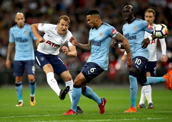 Jamaal Lascelles puts the pressure on Tottenham striker Harry Kane, but the England star still gets his shot away.